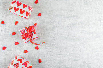 Valentine's Day Gifts background. Gift boxes with red ribbon and red hearts on light grey background. Valentines day card, spase for text. Flat lay, top view, copy space