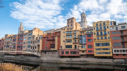 Colorful houses reflected in the Onyar river, in Girona, Catalonia, Spain. Church of Sant Feliu and Cathedral of Santa María in the background