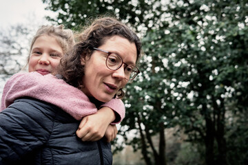 Fototapeta premium Le poids de l'amour : une mère dévouée transporte sa fille avec tendresse
