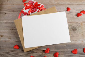 Blank wedding invitation stationery card mockup with envelope and red hearts and gifts on rustic wooden background. Valentines day card, valentines day background, Mothers day card