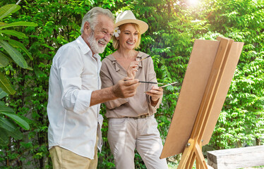 Portrait happy senior couple caucasian artist mature man  woman paint with water color outdoor greenery class. Old creative gifted artist class work shop school education. Activity hobby lifestyle.