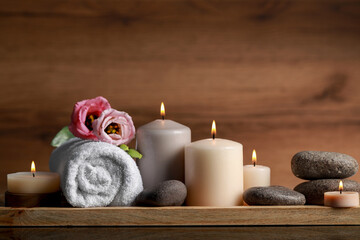 Plakat Beautiful composition with spa stones, flowers and burning candles on mirror table against wooden background