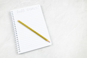 2023 Goals handwritten on the notes paper with wooden pen and copy space