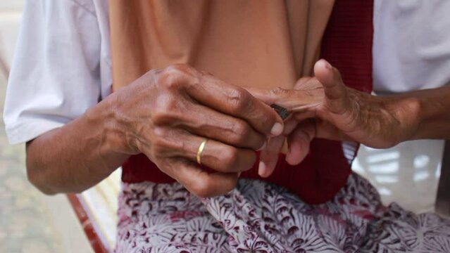 Asian Woman Cutting Nails with Razor