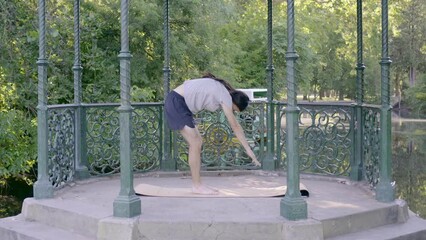 Young hippie latin man with long hair stretching the hamstrings by toe touching exercise. Video 4k.
