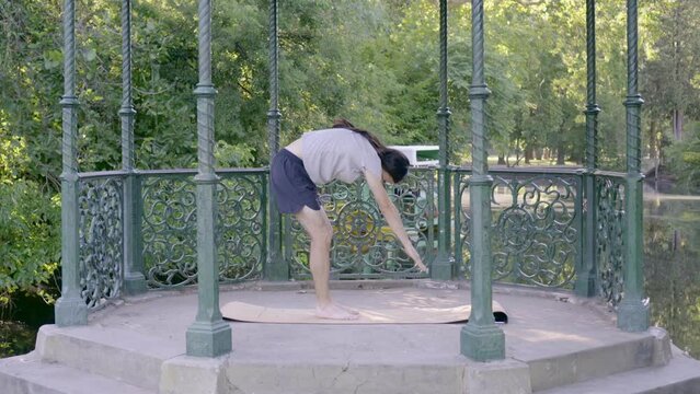 Young hippie latin man with long hair stretching the hamstrings by toe touching exercise. Video 4k.