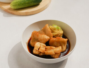 Pempek a traditional food from Palembang Indonesia, served with sour sauce, noodles, and cucumber