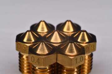 3D printer brass nozzle. Macro of different printer nozzle sizes. Threaded brass nozzles. Parts for 3D printer