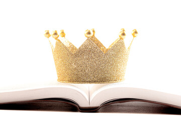 A Golden Crown on a Holy Bible on a White Background