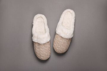 Pair of beautiful soft slippers on grey background, top view