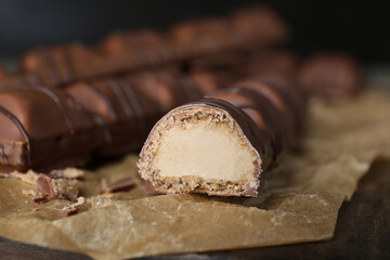 Tasty chocolate bars on wooden board, closeup
