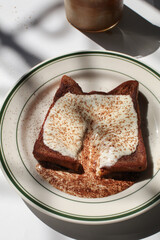 Homemade french toast with cream and cocoa powder on white background. Classic American restaurant breakfast or brunch favorite. 