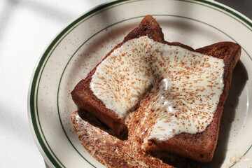 Homemade french toast with cream and cocoa powder on white background. Classic American restaurant breakfast or brunch favorite. 