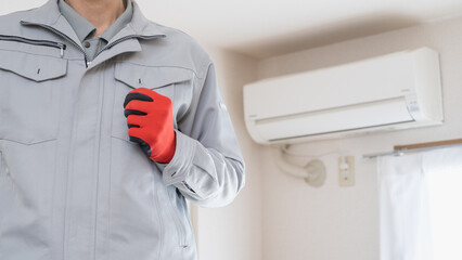 エアコンの掃除・点検をする作業服の男性