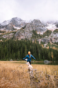 Girl with her dog hiking in the mountains