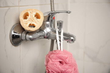 Different sponges on faucet in bathroom, closeup