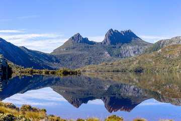 wide shot of cradle mountain reflected on dove lake on a calm summer morning at cradle mountain national park