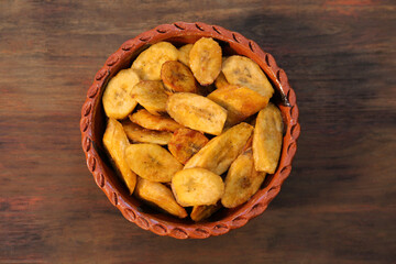 Tasty deep fried banana slices on wooden table, top view