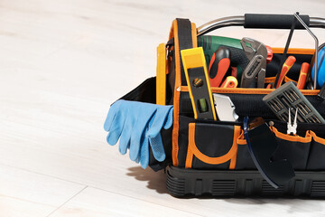 Obraz premium Bag with different tools for repair on white wooden table, space for text