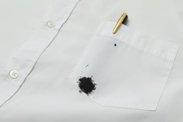 White shirt with stain of black ink and pen in pocket, closeup