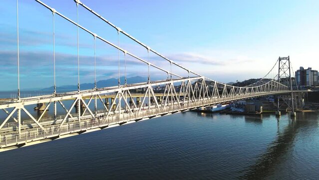 Aerial drone scene of hercilio luz bridge in florianópolis urban center in santa catarina cable-stayed bridge suspended in city with people walking on the bridge