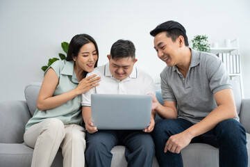 Fototapeta premium Asian happy family, parents using laptop with young son in living room.