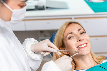 Portrait of Caucasian woman patient and dentist at health care clinic. 