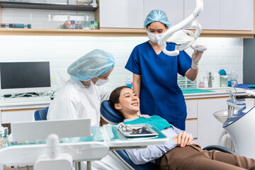 Obraz premium Caucasian dentist examine tooth for young girl at dental health clinic. 