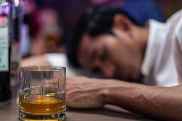 Asian depression man feeling heart broken and drinking beer in a bar.