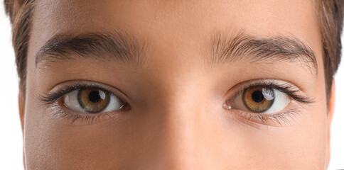 Little boy with brown eyes on white background, closeup