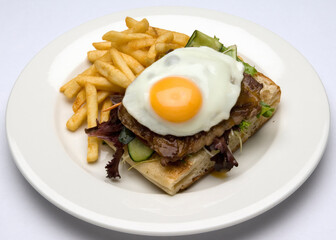 Steak Sandwich with fried egg and fried potatoes