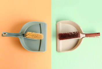 Dustpans and brushes on color background
