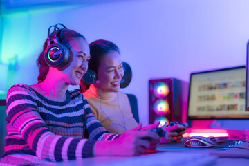 Asian woman gamer play online game with joystick and computer