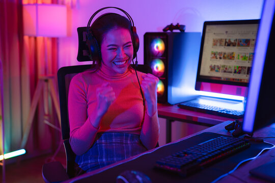 Asian woman gamer play online game with joystick and computer