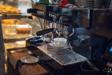 Women barista in an apron making coffee in a coffee shop