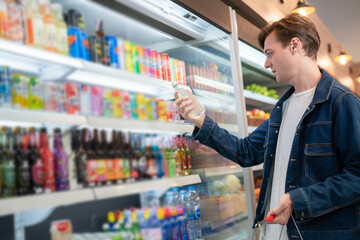 An European man but a bottle of mineral water from refrigerator cold in onvenience store