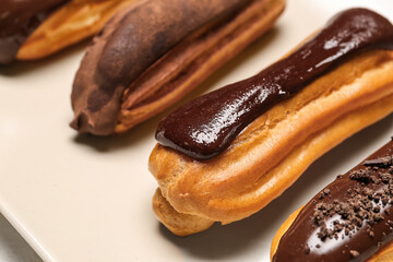 Plate with chocolate eclairs, closeup