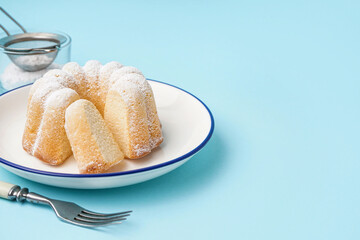 Plate with delicious cake and fork on blue background