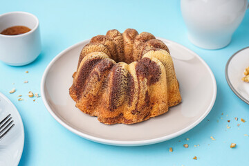 Plate with delicious cake on blue background