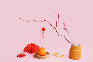 Mandarin, tree branches and Chinese symbols on pink background