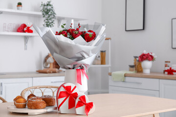 Vase with flowers, pastries and gifts for Valentine's Day on dining table in kitchen
