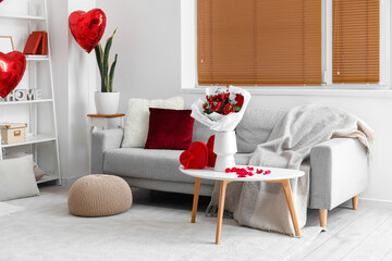 Interior of living room decorated for Valentine's Day with flowers, sofa and gifts