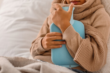 Ill boy with hot water bottle in bedroom, closeup