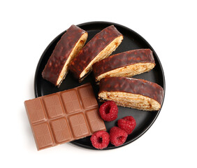 Plate with pieces of tasty sponge cake roll, milk chocolate and raspberry isolated on white background