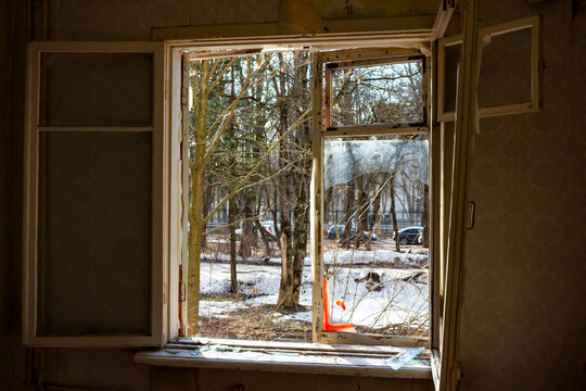 Broken window in an abandoned house, view from the room