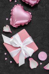 Composition with gift box, balloon and candle on dark background, closeup. Valentine's Day celebration
