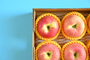 beautiful pink apple in the box on blue background