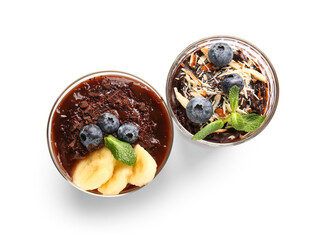 Glasses of delicious chocolate pudding with blueberry, banana and mint isolated on white background