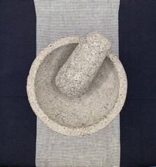 Mexican traditional stone mortar on blue and white table cloth