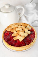 Stand with sweet strawberry pie, cookie hearts and teapot for Valentine's day on white table